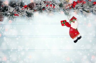 noel santa oyuncak kış dalları koniler ve mavi ahşap doku üzerinde kar                              