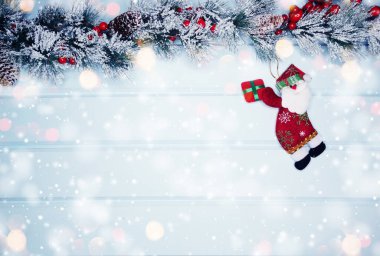 noel santa oyuncak kış dalları koniler ve mavi ahşap doku üzerinde kar                              