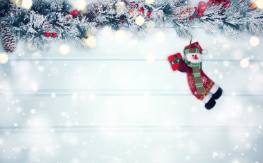 mavi ahşap doku üzerinde noel kardan adam oyuncak kış dalları konileri ve kar                              