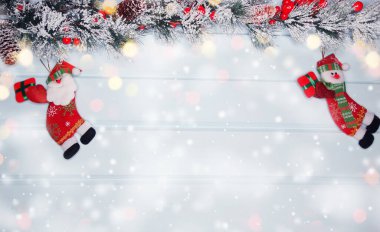 noel santa oyuncak kış dalları koniler ve mavi ahşap doku üzerinde kar                              