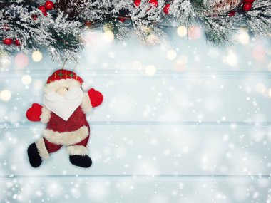 noel santa oyuncak kış dalları koniler ve mavi ahşap doku üzerinde kar                              