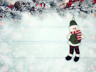 mavi ahşap doku üzerinde noel kardan adam oyuncak kış dalları konileri ve kar                              