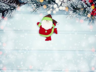 noel santa oyuncak kış dalları koniler ve mavi ahşap doku üzerinde kar                              