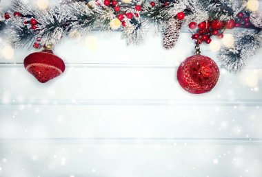 Kış Noel arkaplanında köknar dalları ve mavi ahşap dokuda kar var.                              