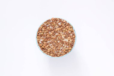 Kuru gevrekler yuvarlak bir fincanda beyaz arka planda karıştırılır