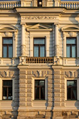 Eski binanın ön cephesinde oyulmuş sütunlar, sütunlar, tavan arası ve diğer mimari dekorasyonlar. Ön görünüm.