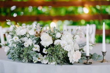 Ziyafet masası mumlar ve çiçek düzenlemeleri ile süslenmiştir. Yüksek kalite fotoğraf