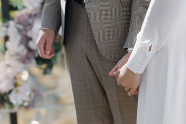Damat gelinin elini tutuyor. Eller yeni evlilere yakındır. Yüksek kalite fotoğraf
