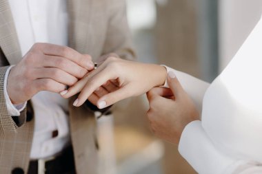 Evlilik yüzükleri. Damat nikah yüzüğünü geline takar. Yakın plan..