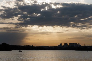 Gün batımında sudan şehre bak.