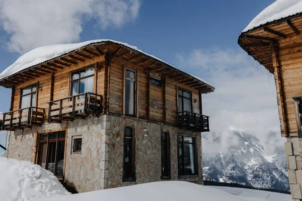 Cottage in legno sullo sfondo delle montagne innevate — Foto Stock
