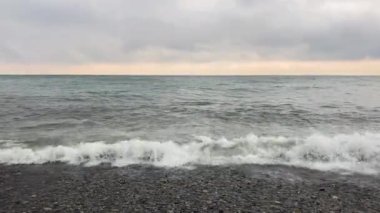 Deniz dalgaları bulutlu bir gökyüzüne karşı