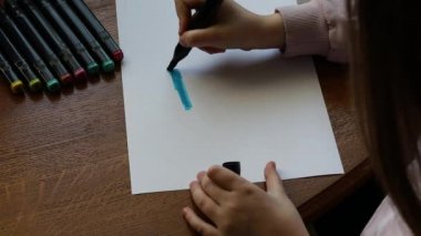 Küçük bir kız Ukrayna bayrağını bir kalemle çiziyor. Çocuk resimleri çiziyor. Ukrayna 'da Savaş.