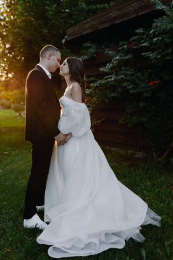  Güzel gelin ve damat gün batımında sarılıyor. Dikey fotoğraf. Yüksek kalite fotoğraf