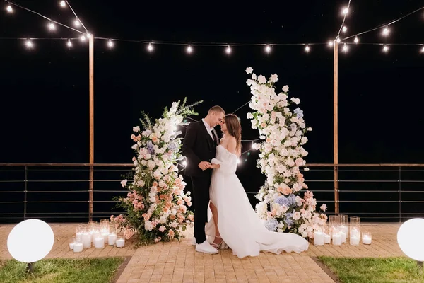 Das Brautpaar Der Nähe Des Bogens Bei Der Abendlichen Zeremonie — Stockfoto