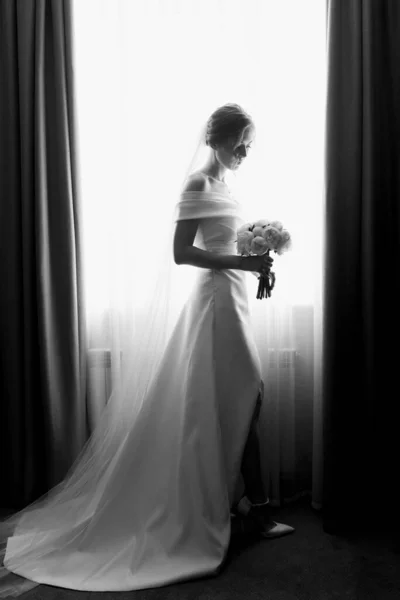 Красивая Невеста Белом Платье Стоит Окна Смотрит Букет Черно Белая — стоковое фото