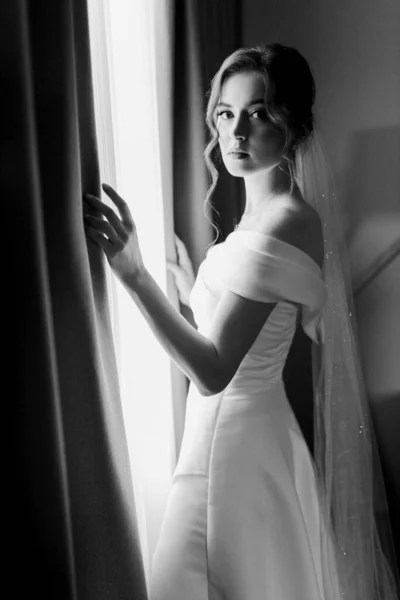 Счастливая Невеста Белом Платье Открывает Занавески Гостиничном Номере Смотрит Камеру — стоковое фото