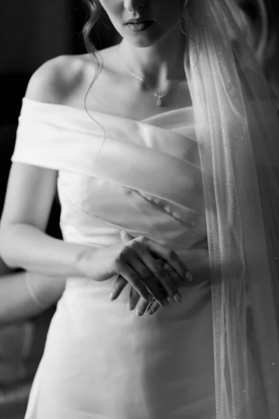 Piękna Panna Młoda Stoi Przy Oknie Białej Sukience Trzyma Ręce — Zdjęcie stockowe