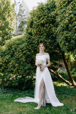 Gelinlik beyaz bir elbise içinde elinde bir buket çiçek olan bir gelin. Yüksek kalite fotoğraf