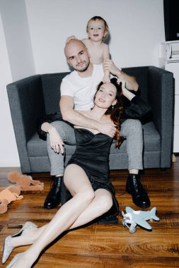  Genç bir aile evdeki kanepede poz veriyor. Yüksek kalite fotoğraf