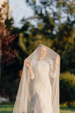  Gelin, gün batımında açık havada, yeşilliğin arka planında. Yüksek kalite fotoğraf