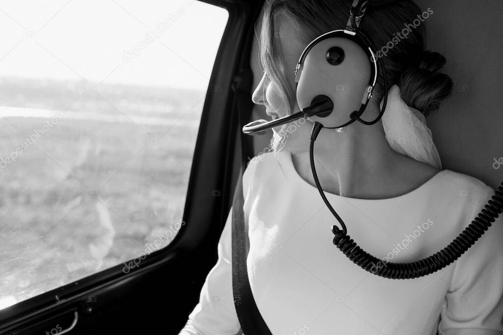  The bride is sitting in a helicopter. Black and white photo. High quality photo