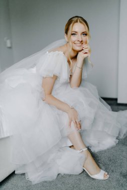 Yatakta oturan zarif gelinlikli genç gelin. Düğün günü. Yüksek kalite fotoğraf