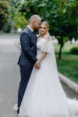  Parkta birlikte poz verip kameraya bakan zarif gelin ve damat. Yüksek kalite fotoğraf