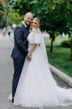  Mutlu yeni evli çift kucaklaşıp kameraya bakıyor. Yüksek kalite fotoğraf