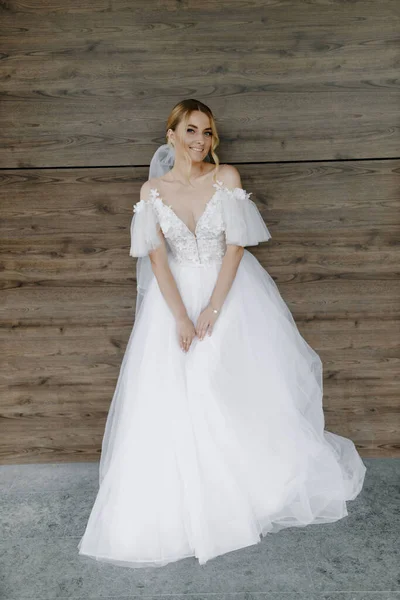 Güzel kahverengi saçlı gelin yeni bir binanın duvarında poz veriyor. Yüksek kalite fotoğraf