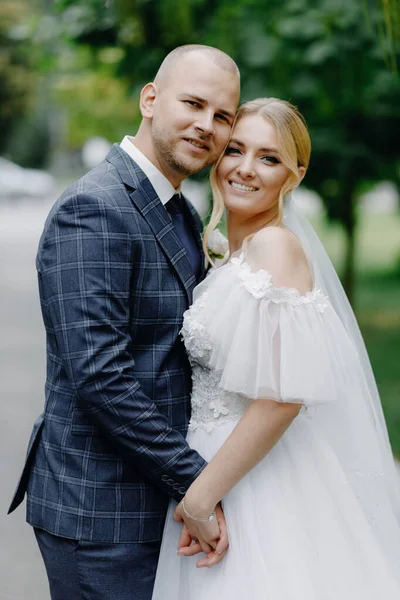  Mutlu yeni evli çift kucaklaşıp kameraya bakıyor. Kapatın. Yüksek kalite fotoğraf