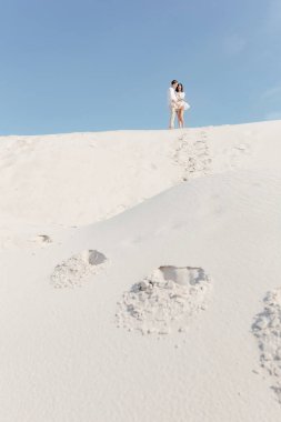  Genç çift yazın kumlu sahilde yürür. Mesajın için yer aç. Yüksek kalite fotoğraf