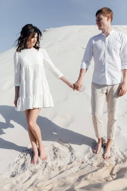 Mutlu çift yazın mavi gökyüzünün arka planında dağ yamacında poz veriyor. Yüksek kalite fotoğraf