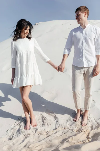 Mutlu çift yazın mavi gökyüzünün arka planında dağ yamacında poz veriyor. Yüksek kalite fotoğraf