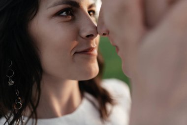 Genç esmer, sevgi dolu bir kocanın gözlerinin içine bakar ve gülümser. Kapatın. Yüksek kalite fotoğraf