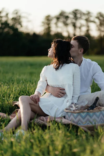 美丽的一对恋人在夕阳西下坐在绿草上 公园里浪漫的爱情故事高质量的照片 — 图库照片