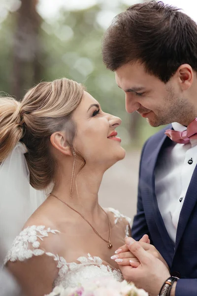 Gelin ve damat bir çam ormanında birbirlerine sarılıyorlar. Kapatın. Yüksek kalite fotoğraf