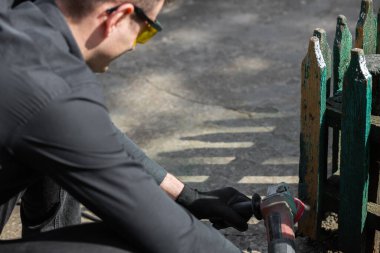 Zımparalamak ve boyamak için ahşap bir çit hazırlamak. Efendi evin yakınında yenileniyor. Kapatın. Yüksek kalite fotoğraf
