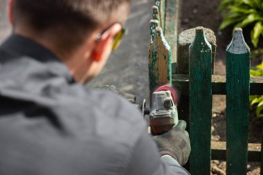 Zımparalamak ve boyamak için ahşap bir çit hazırlamak. Efendi evin yakınında yenileniyor. Kapatın. Yüksek kalite fotoğraf