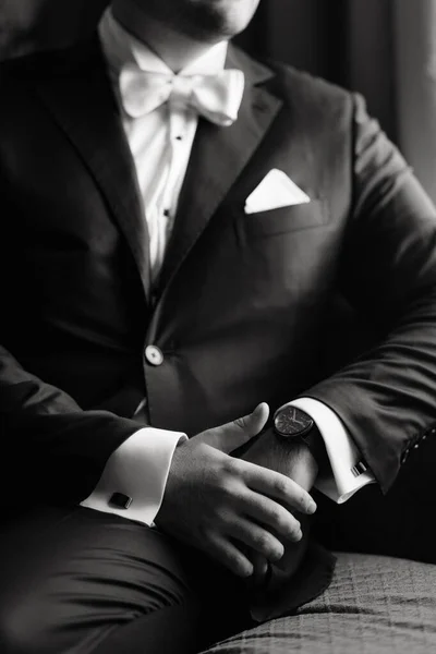 Stylish suit with butterfly close up. Businessman in luxury style. Elegant young handsome man. Men\'s jacket, hand button cover. Business style. Black and white photo. High quality photo