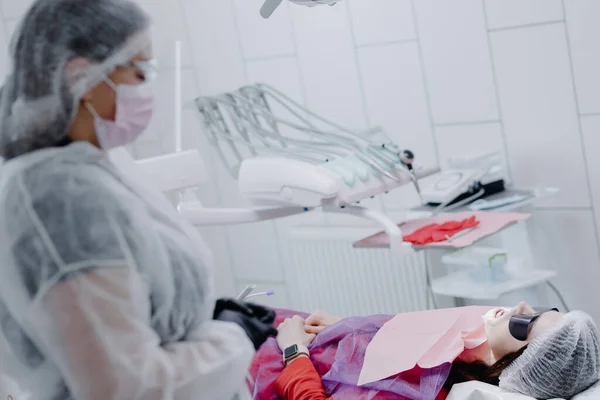 A female dentist in a dental office prepares a patient for treatment. High quality photo