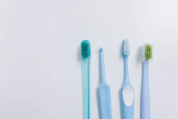 Four Toothbrushes Different Heights White Background High Quality Photo — Fotografie, imagine de stoc