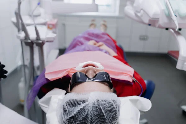 Pacjent Leży Krześle Dentystycznym Okularach Przygotowuję Się Mycia Zębów Wysokiej — Zdjęcie stockowe