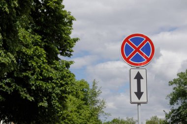  İşaretin önünde ve dışında durmanın ve park etmenin yasak olduğunu belirten bir Avrupa yol tabelası. Mavi gökyüzü ve arka planda doğa. Yüksek kalite fotoğraf
