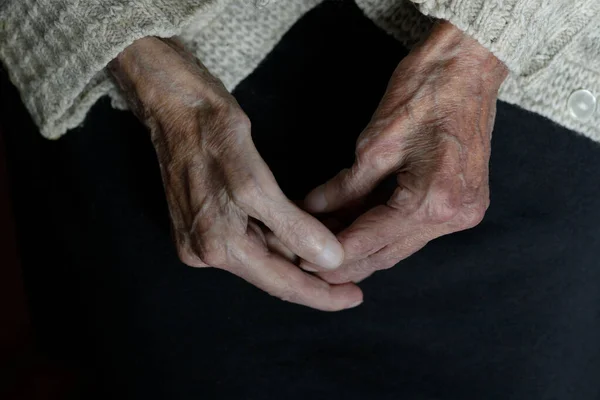 Hands of an old woman on a black background. Aging process. High quality photo