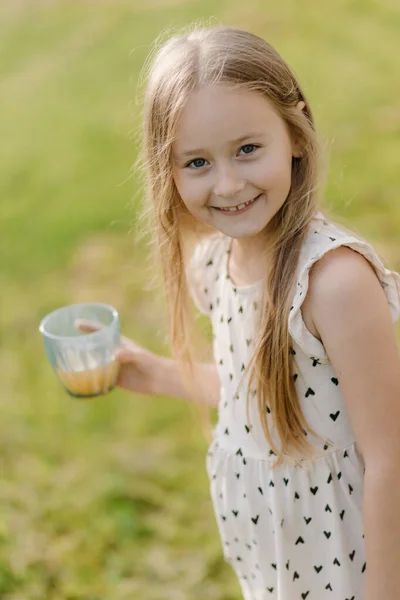 Dışarıda Elinde Meyve Suyuyla Kameraya Bakıp Gülümseyen Güzel Küçük Bir — Stok fotoğraf