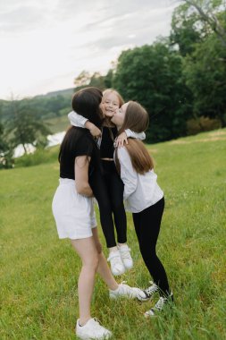  Mother and two daughters play in the park in summer. Happy family concept. Vertycal photo. High quality photo