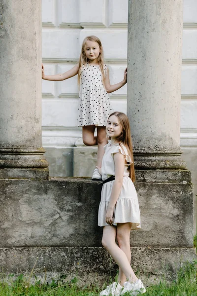 Sisters Little Girls Dresses Stand Columns Pose Camera High Quality — Fotografia de Stock