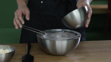 Un hamuru. Mutfakta un eleme işlemi. Kadınlar un elleyerek süzgeçten geçiriyorlar. Ev yapımı hamur ve hamur işi. - Evet. Yüksek kalite 4k görüntü