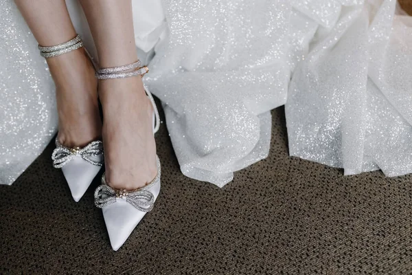 Wedding shoes with rhinestones on the feet of the bride. High quality photo